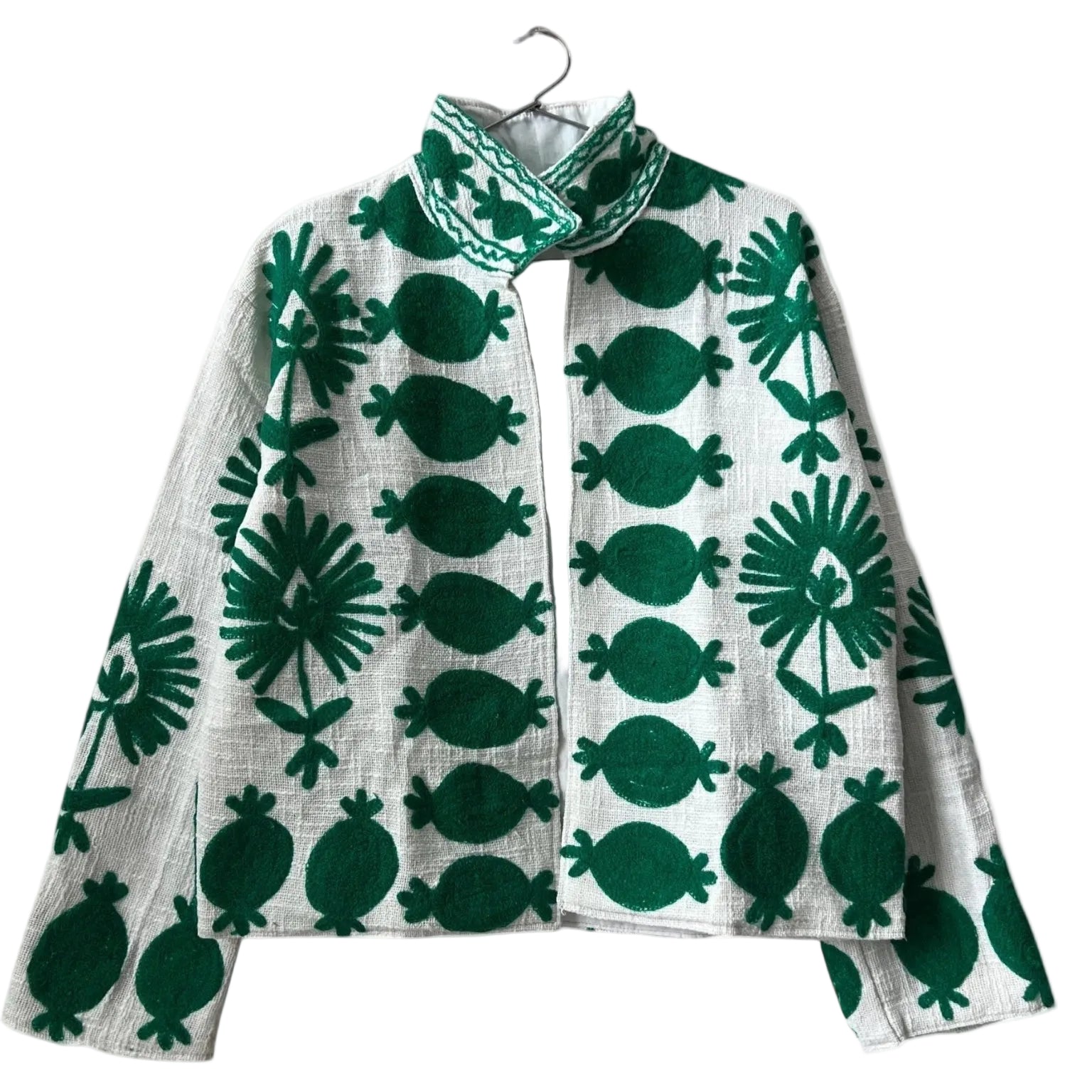 ront view of an open-style handmade white textured cotton TNT short jacket featuring bold, large-scale emerald green Suzani embroidery with floral and botanical motifs, isolated against a solid white background.