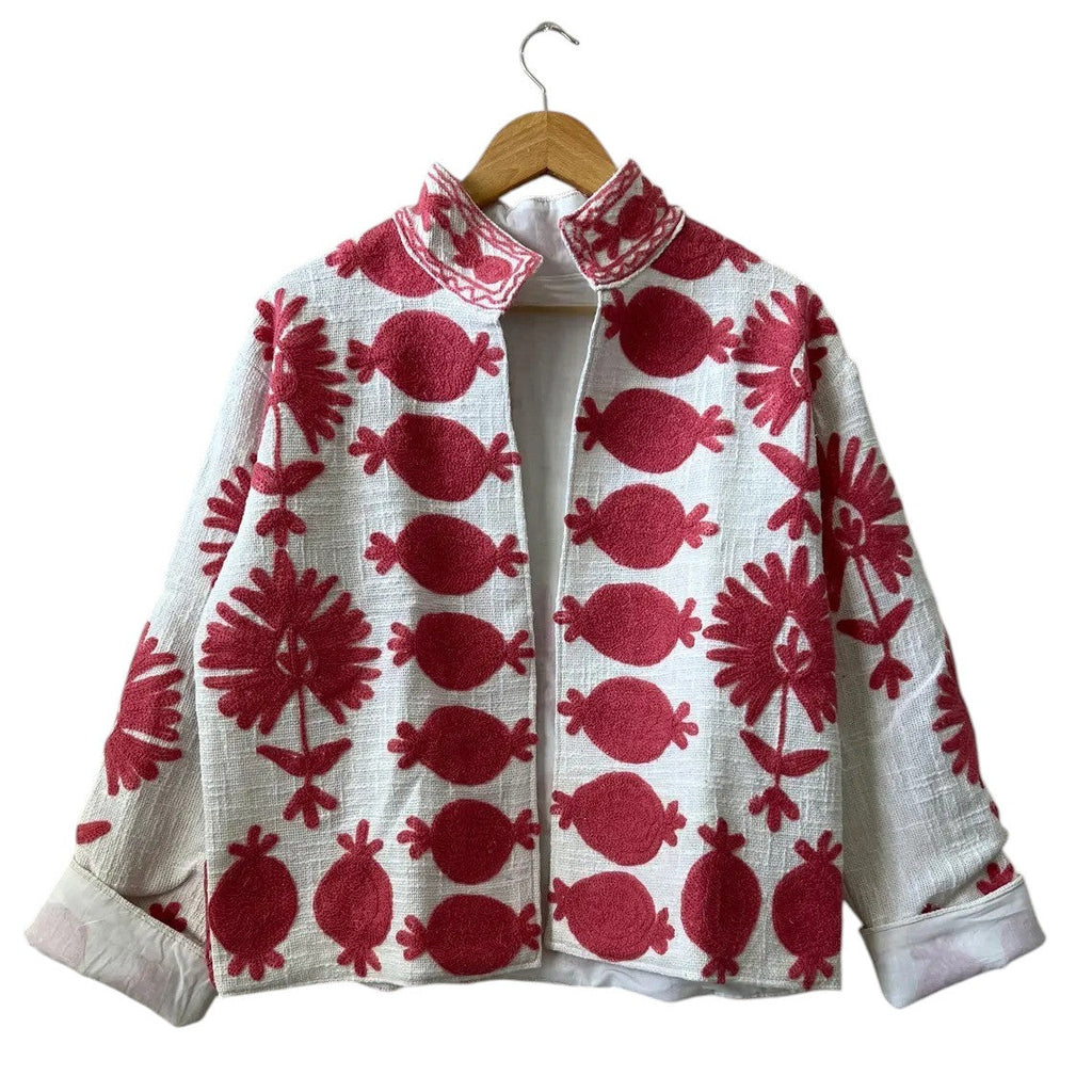Front view of an open-style handmade white textured cotton TNT short jacket featuring bold, large-scale red Suzani embroidery with floral and pomegranate-like botanical motifs, isolated against a solid white background.
