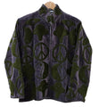 A dark grey velvet statement jacket on a wooden hanger. It features large, contrasting olive green retro symbols all over, including peace signs, yin-yang symbols, and abstract mystic shapes. The jacket has a stand collar, long sleeves, and an open front.