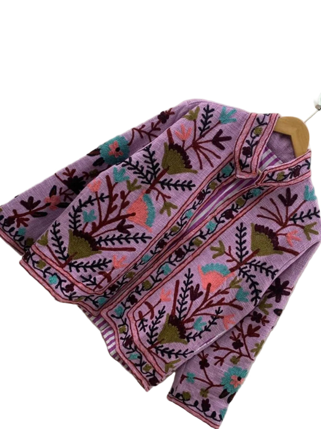 TNT jacket featuring teal, coral pink, and olive green Suzani floral embroidery, showcasing a purple-and-white striped interior lining, hanging on a wooden hanger against a white wall.
