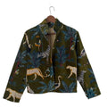 Back view of a dark green velvet TNT jacket featuring a colorful tropical safari print with cheetahs, zebras, exotic birds, and palm leaves.