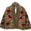 Front view of an open-style handmade beige textured cotton TNT short jacket featuring vibrant red and deep purple Suzani fan-floral embroidery with green leaves and tan branches.