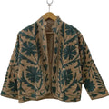 Front view of an open-style handmade khaki textured cotton TNT short jacket featuring dark green monochrome Suzani floral and vine embroidery, showcasing a solid tan interior lining.
