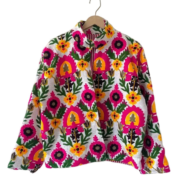 Front view of an open-style handmade white textured cotton TNT short jacket featuring a dense, all-over pattern of bright hot pink, yellow, and green Suzani floral embroidery.